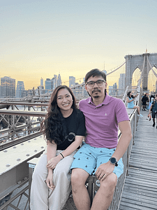 New York City attraciton couple shot sitting on Brooklyn Bridge