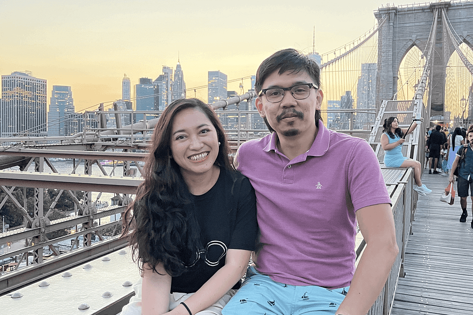 New York City attraciton couple shot sitting on Brooklyn Bridge